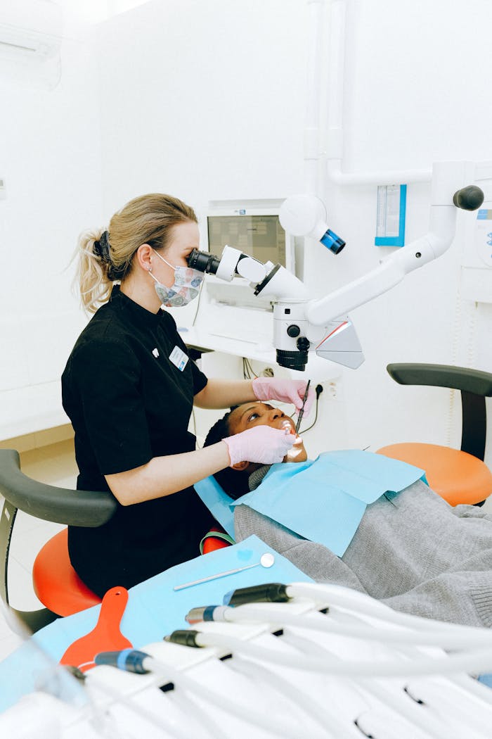 Female dentist in clinic examining a patient with modern dental equipment.